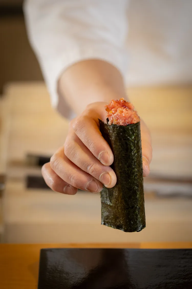 鮪魚泥鮭魚卵手卷將鮪魚赤身、中腹、大腹去筋剁成絲滑泥狀，搭配鹽漬鮭魚卵及日本清淨海域厚感海苔，加入日本大蔥與經蘋果木煙燻的日式醃蘿蔔，每一口都是新經典。業者提供