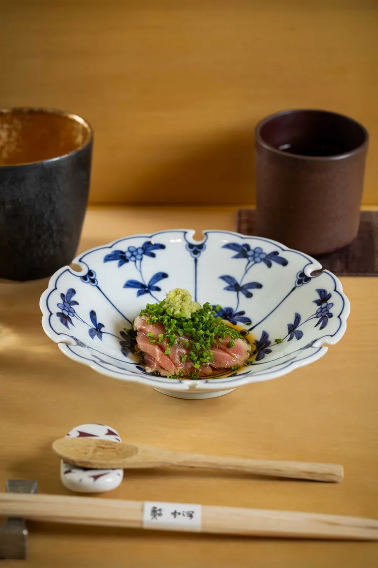 鮪魚腦天選用鮪魚魚頭左右各僅有一塊的珍稀部位，經昆布高湯川燙，再以精湛刀工細膩修整筋膜。搭配祖傳自製橙醋的酸香，佐以日本細蔥與現磨山葵共譜味蕾三重奏。業者提供