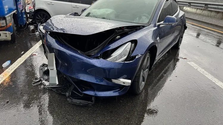 特斯拉王姓駕駛站在外側路肩等待道路救援，反遭小貨車撞擊，導致左腳骨折送醫。翻攝畫面