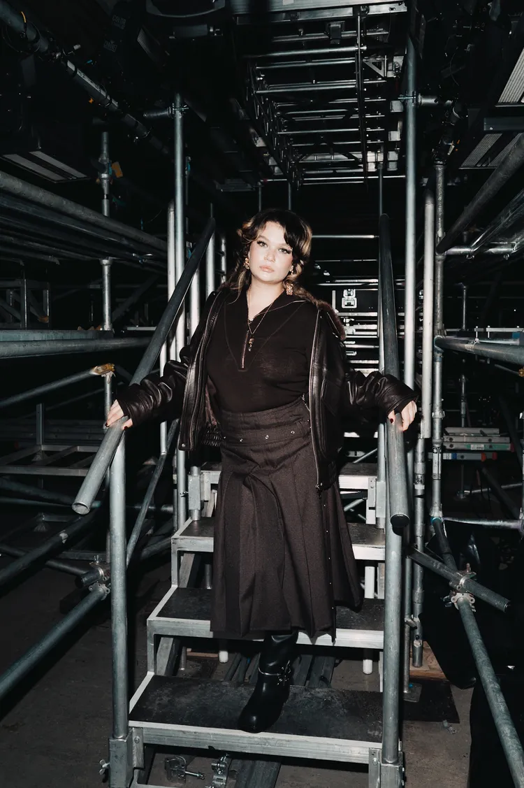 爆紅的英國歌手Lola Young身穿皮革夾克、百褶裙與高筒長靴，個性十足。品牌提供