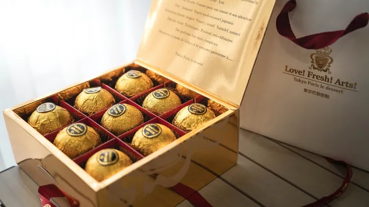東京巴黎甜點「金莎菠蘿蛋黃酥」9入款閃耀金黃禮盒，另搭配紅色燙金印花緞帶蝴蝶結裝飾。東京巴黎甜點提供
