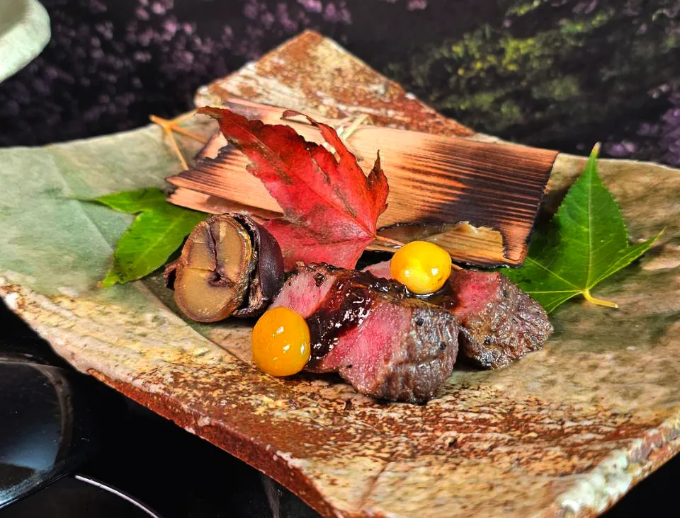 台北美福晴山日本料理推出「食之都美食大使 匠心旬味」晚间套餐,烤物「沙朗牛网烧、滨纳豆酱、䲠鱼杉板烧、银杏栗子扬」,带有弹牙口感及温润油脂的沙朗牛,搭配静冈县滨松的特产「滨纳豆」调制的佐酱。台北美福大饭店提供