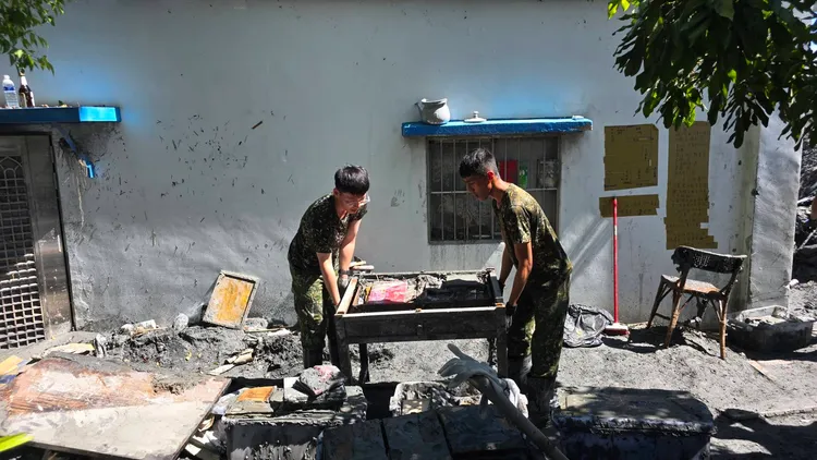 國軍弟兄協力把赫恪毀損的書桌移出家屋。讀者提供