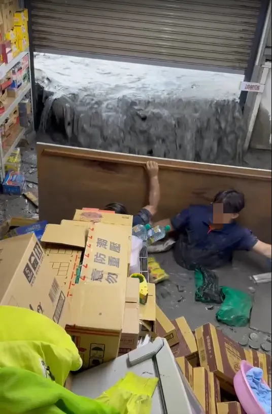 2員工用木板拼命擋水。翻攝畫面