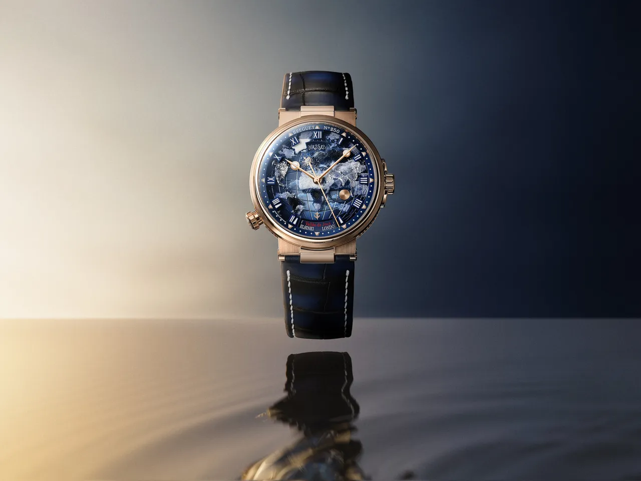 宝玑Marine Hora Mundi 5555腕表,43.9mm,18K宝玑金表壳,18K金渐变机刻雕花与半透明蓝宝石水晶玻璃表盘,海军蓝色大鳞纹鳄鱼皮表带,77F1型自动上链机芯,动力储存55小时,防水深度100米,限量50只。品牌提供