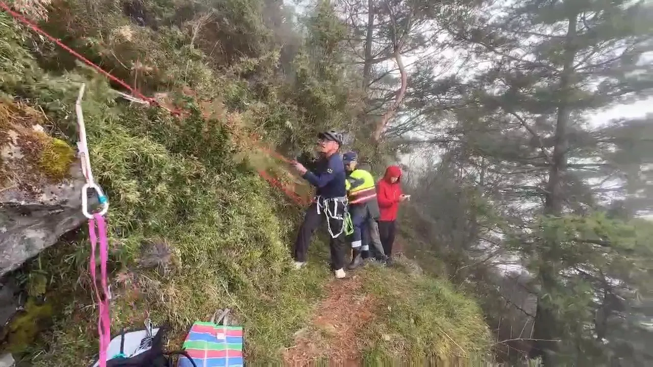 女登山客踩空滑落邊坡,一時無法動彈,警消即刻救援。翻攝畫面