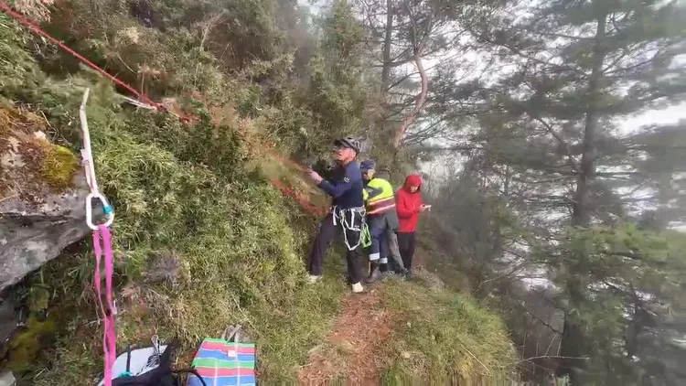 女登山客踩空滑落邊坡，一時無法動彈，警消即刻救援。翻攝畫面