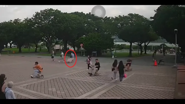 殷姓媳婦8/6當天拖著紅色行李箱(紅圈)穿越淡水捷運站至河岸的畫面。翻攝畫面