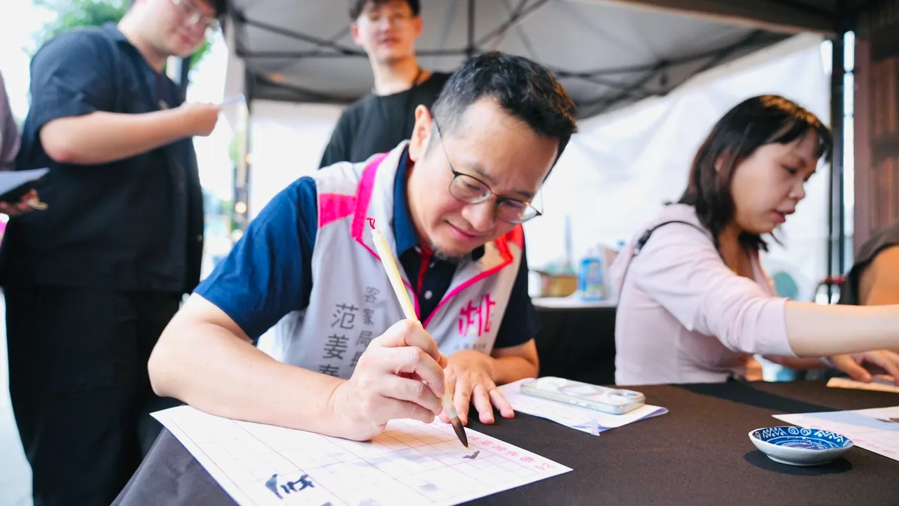 客家局長范姜泰基現場體驗書法活動,揮毫感受傳統文化魅力。客家局提供