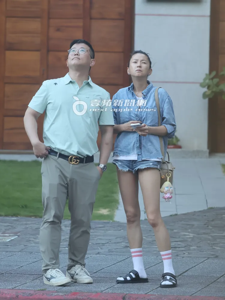 六月和GUCCI男勾著手漫步人行道，駐足望著遠方天色。特勤中心攝