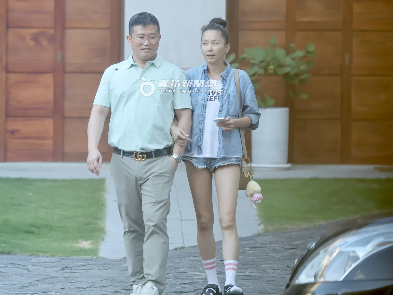 六月(右)肩背约40万元爱马仕Mini Lindy,勾GUCCI男一路走到路边。特勤中心摄
