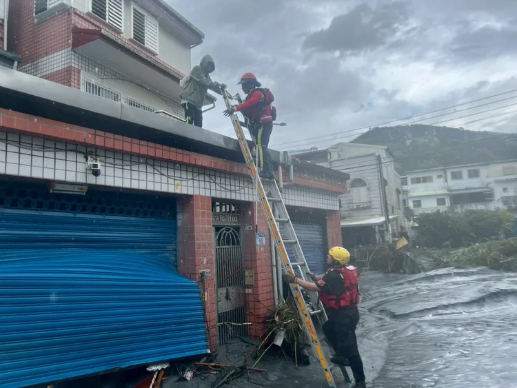 特搜人員架鐵梯爬上二樓救援。翻攝畫面