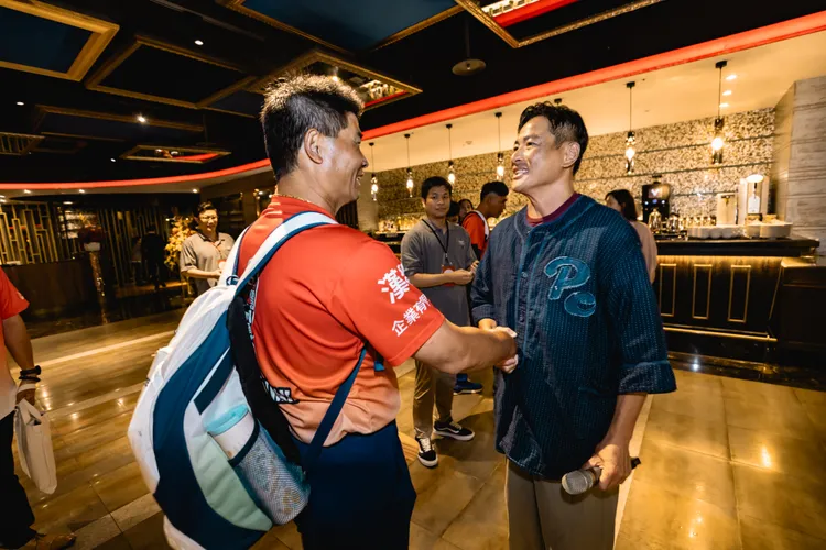 江宏恩（右）在慶功宴上和東園少棒總教練賴敏男相談甚歡。美福、台北市政府提供