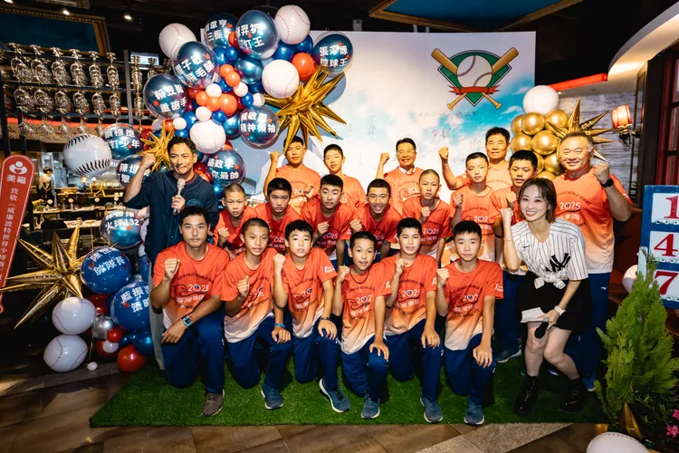 江宏恩（左）、夏語心（右）與東園國小少棒隊合照留念。美福、台北市政府提供