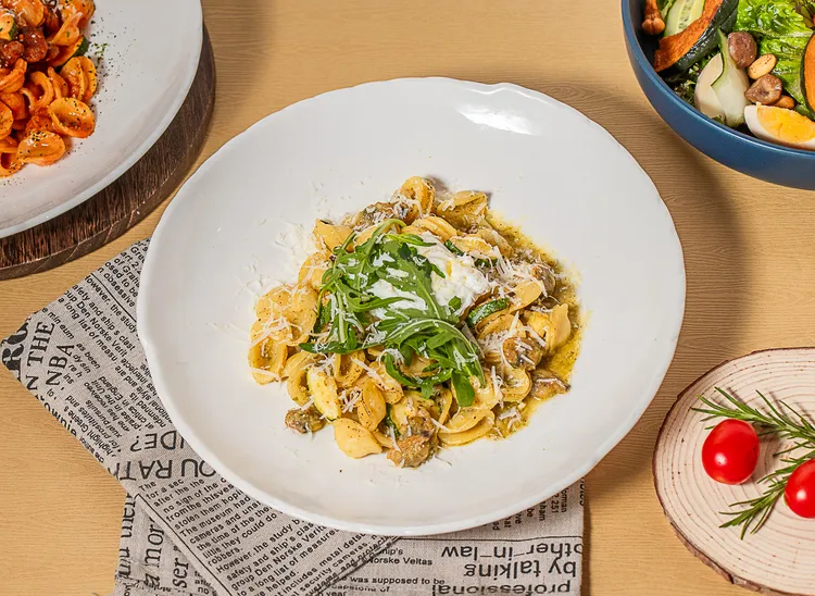 「Puglia青醬海瓜子貓耳朵麵」選用口感扎實、圓潤討喜的貓耳朵麵，搭配以九層塔、蒜頭、初榨橄欖油與松子現打製成的濃郁青醬拌炒，再加入新鮮海瓜子增添自然鮮味。業者提供