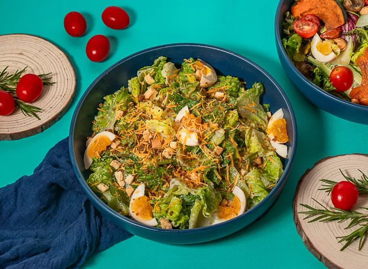 「主廚特製凱撒沙拉」新鮮蘿蔓生菜搭配溏心蛋、酥烤麵包碎，以及主廚手工烘烤自製的鯖魚鬆，入口魚香驚喜於口中綻放，為這道經典沙拉注入獨特的風味。業者提供