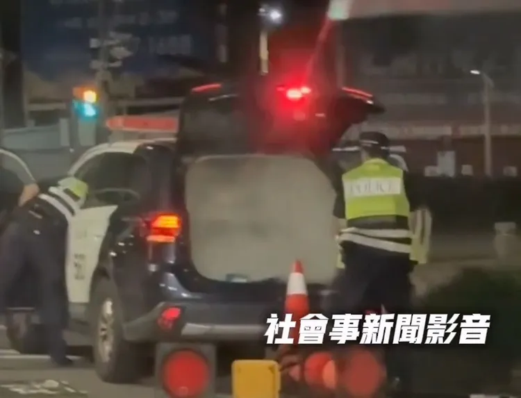 警員以車上的滅火器撲滅火勢，經查是用來啟動警車警示燈、警鳴器的備用電瓶起火。翻攝「社會事新聞影音」