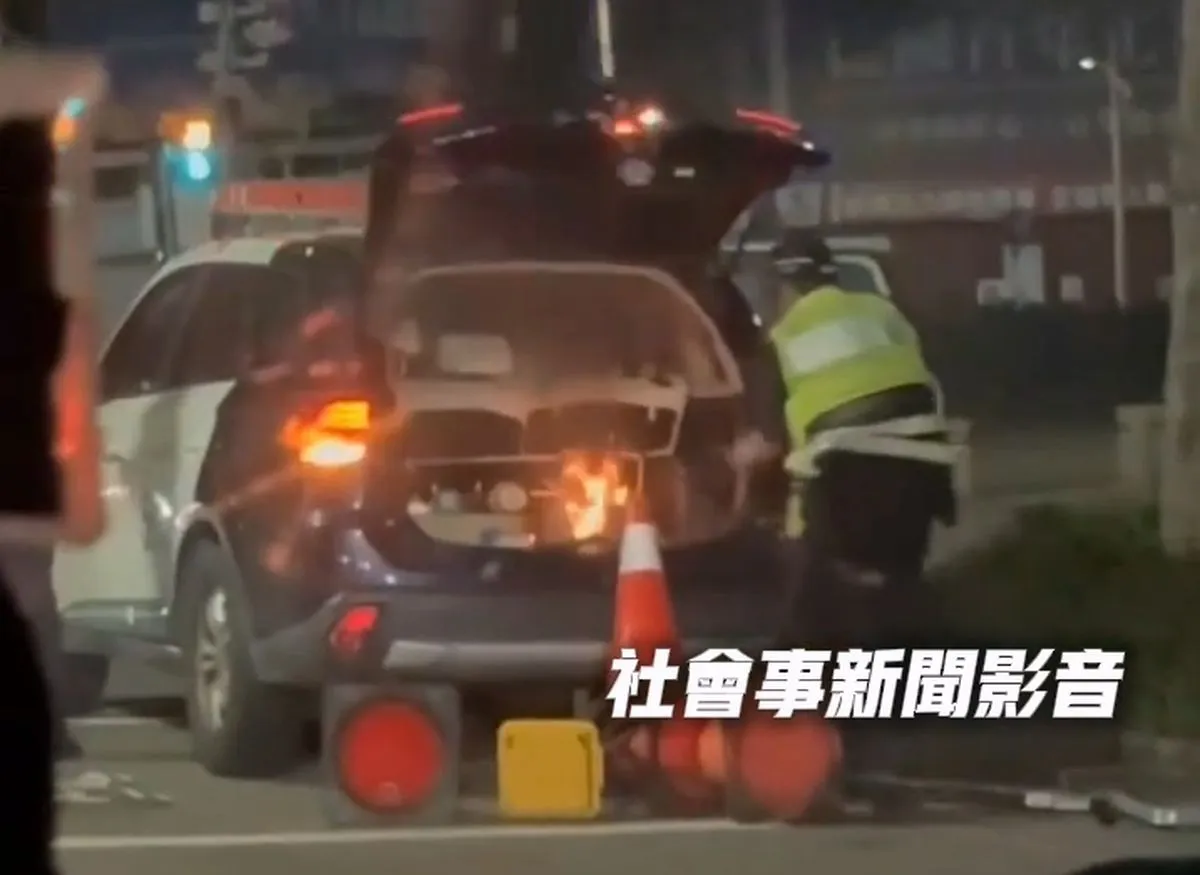 警车后车厢烧起来,警员连忙灭火。翻摄「社会事新闻影音」