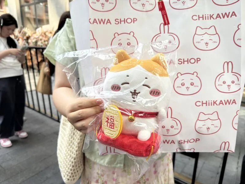 吉伊卡哇上海店贩售限量款式「招财小八」,原价人民币139元,现场黄牛加价400元贩售。图为民众展示购买到的战利品。