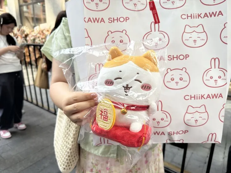 吉伊卡哇上海店販售限量款式「招財小八」，原價人民幣139元，現場黃牛加價400元販售。圖為民眾展示購買到的戰利品。