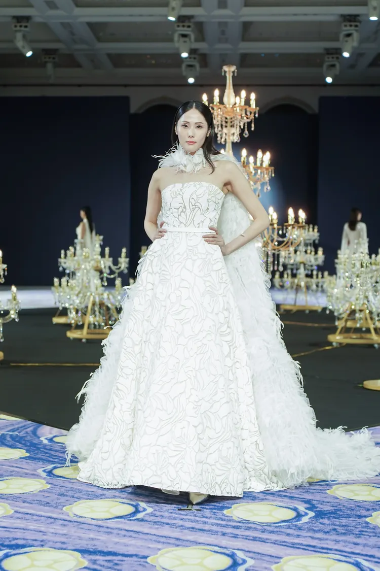 大秀以這件白色花卉洋裝搭配羽毛披風收尾。品牌提供