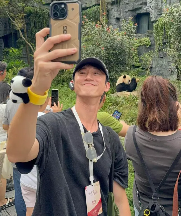 吳慷仁戴上熊貓手環，與熊貓拍同框照。翻攝吳慷仁臉書