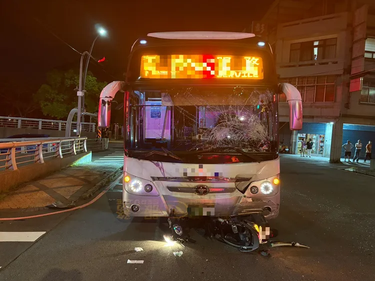 國光客運左前擋風玻璃嚴重碎裂，機車卡在車頭下方。民眾提供