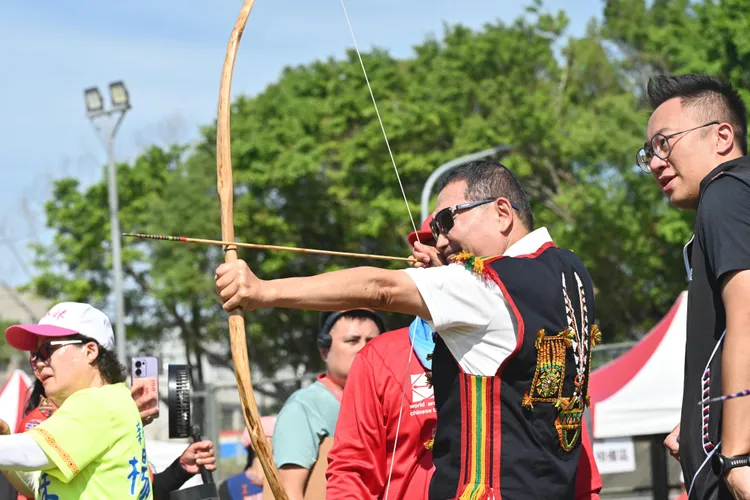 新北市市長侯友宜熱情到場，與傳統射箭賽選手們交流互動，並拉弓展箭技。 原民局提供