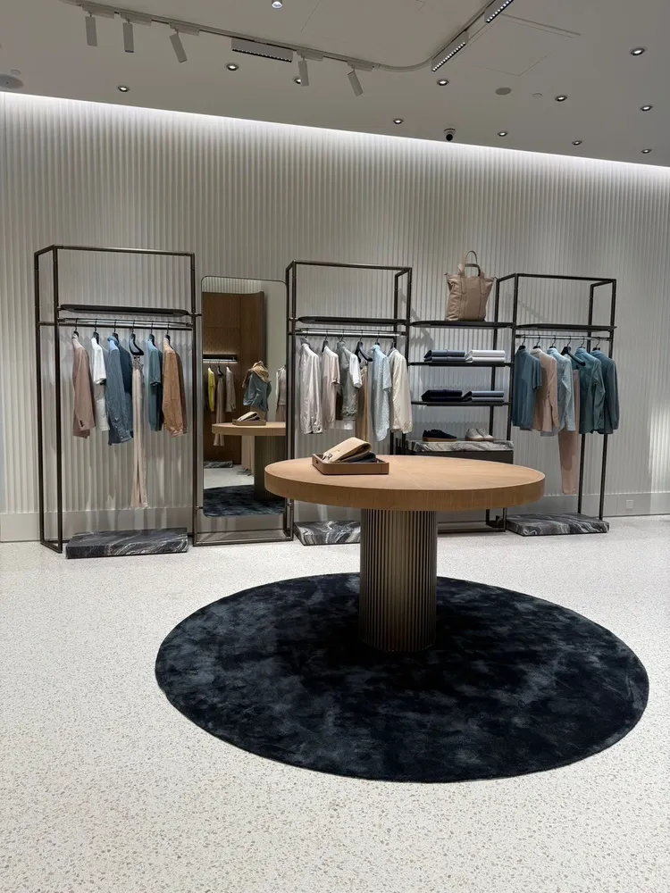 店內以柔和的灰與綠為主色調，搭配香檳金網板與水磨石地板點綴。品牌提供