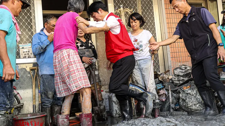 總統賴清德（右3）25日到花蓮關心馬太鞍溪堰塞湖溢流災情，災區布滿泥濘難以行走，有民眾出手扶賴總統一把。中央社