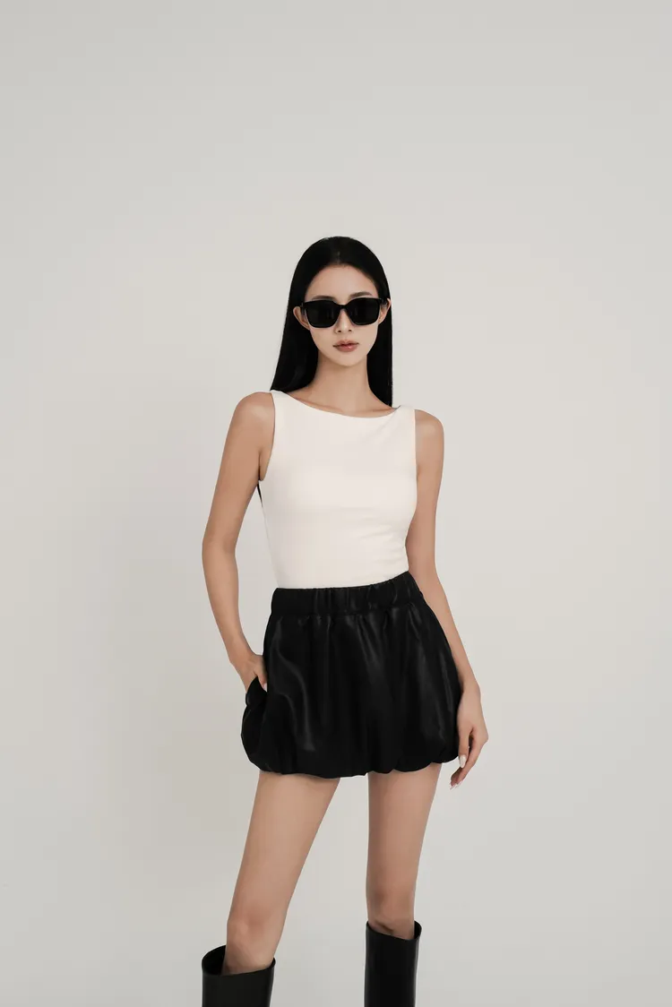 CHENN CHENN天絲船型領BRATOP背心890元、皮革花苞褲裙1280元。品牌提供