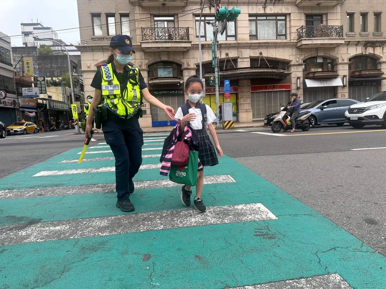 女警贴心陪女童走过行人穿越道,上学之路安全无虞。警方提供