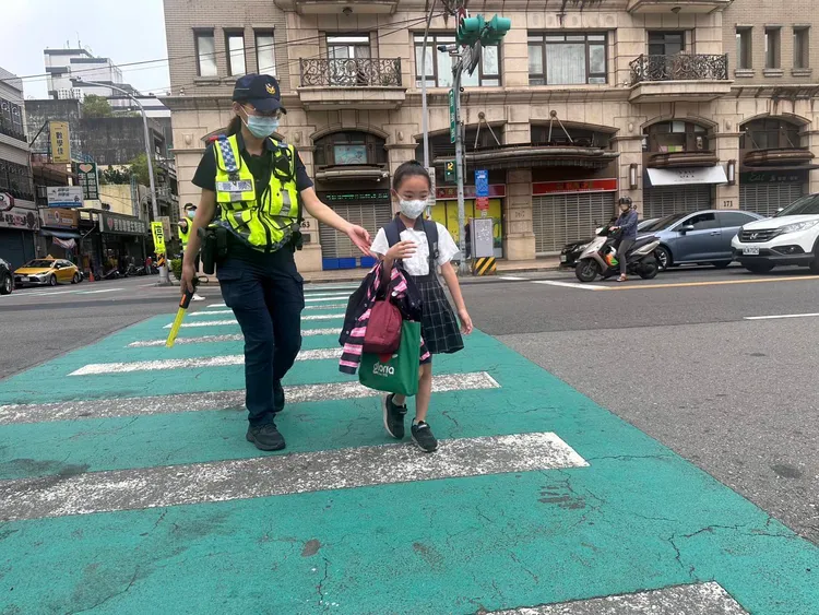 女警貼心陪女童走過行人穿越道，上學之路安全無虞。警方提供