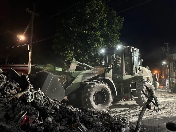 國軍弟兄以大型機具裝鏟廢棄物及爛泥。軍方提供