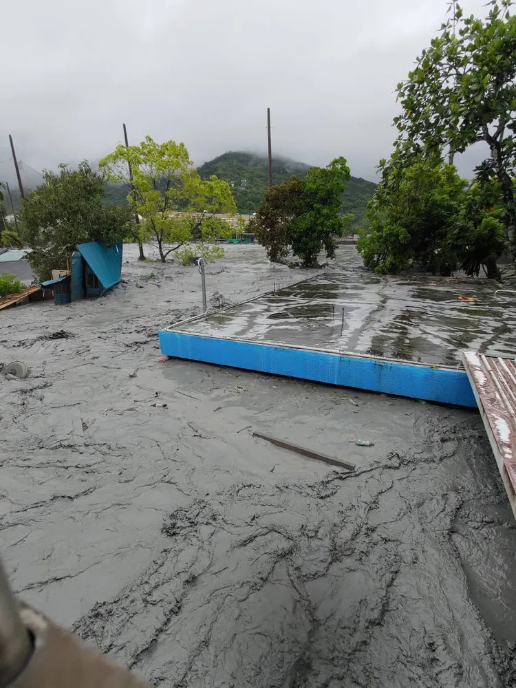 平房幾乎被洪水吞沒，只剩屋頂露出。讀者提供