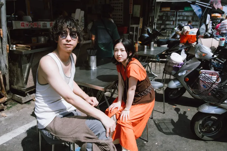 貝斯手Yasukawa Aru（左）、主唱片桐坐在大腸攤前超台。波麗佳音提供