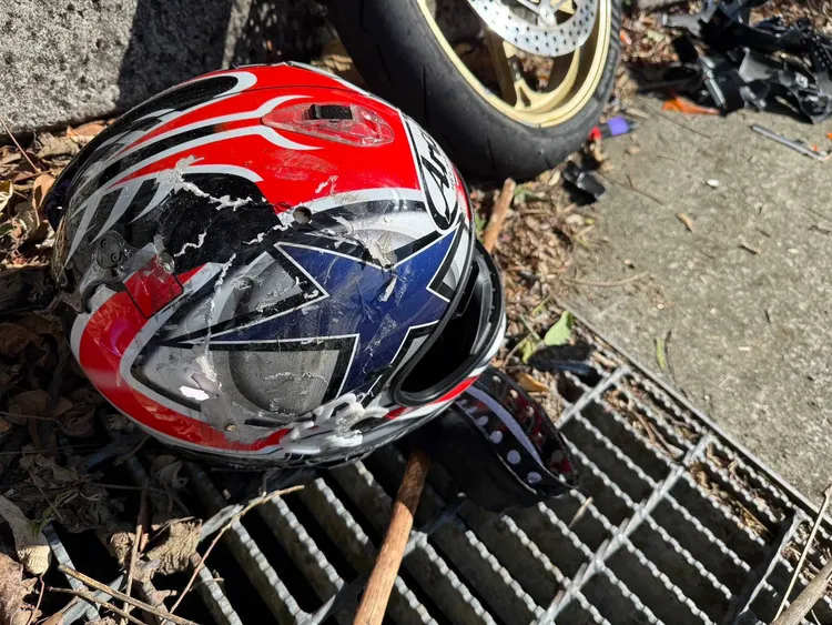 梁男安全帽外殼受損嚴重，可見撞擊力相當之強。翻攝畫面