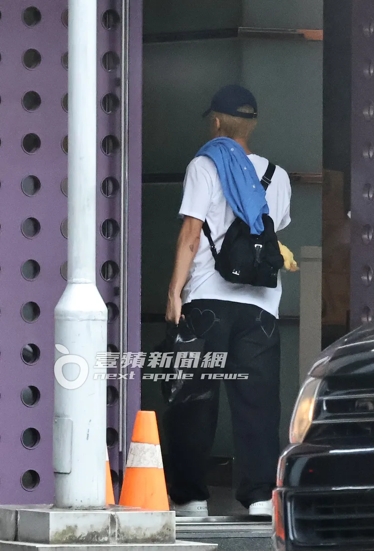 吳克群一身CELINE簡約穿搭，背小包走進家門。特勤中心攝