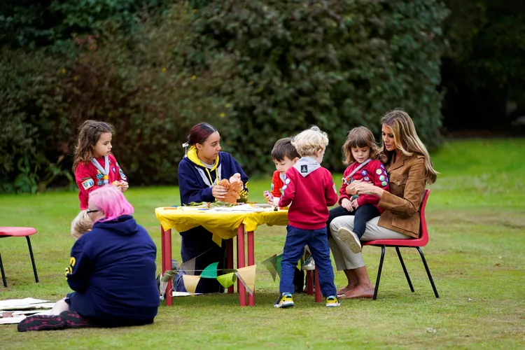 梅蘭妮亞一度把幼童抱在大腿上，展現親和力。路透