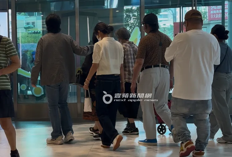 一行人準備走出醫療大樓，蕭敬騰（左）將手搭在蕭媽的背。特勤中心攝