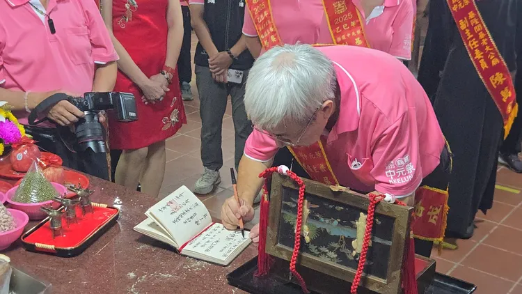 吳姓宗親會主任委員吳春成記錄下關龕門的時辰和參與者姓名。葉先鵬攝