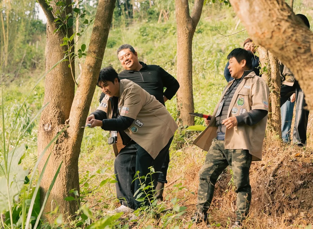 胡釋安(左)嘗試砍樹卻拿反刀子,被笑說到底行不行。客台提供
