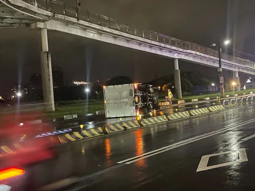 趕著下班?新莊堤外道路貨車打滑撞分隔島側翻 司機雨天飆速畫面曝