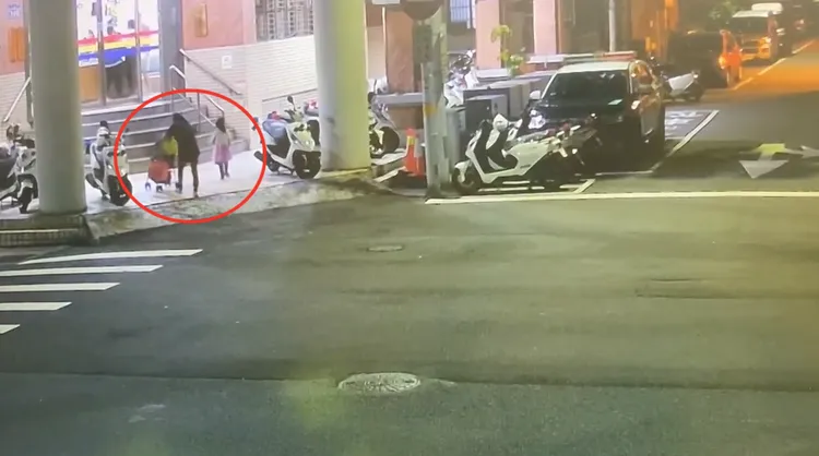 李女帶著2個孩子因肚子餓到沒體力，走到派出所前階梯暫歇。翻攝畫面