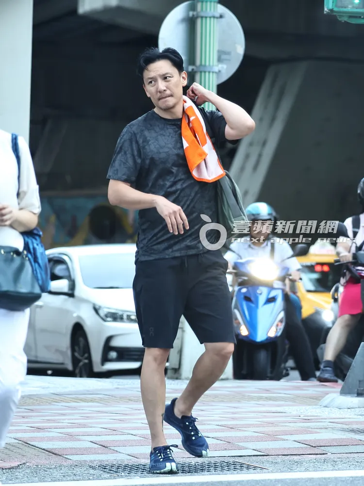 張震肩披運動毛巾擦汗。特勤中心攝