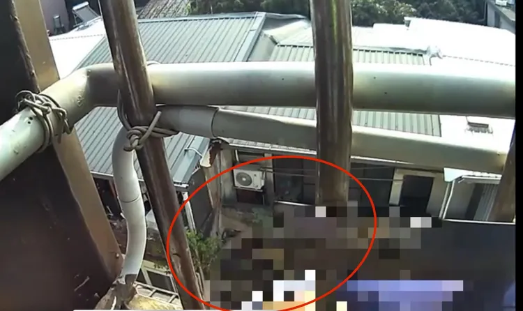 老翁倒臥掛在五樓外牆欄杆上，警員見狀立刻衝上去抓住衣物，避免他摔落。翻攝畫面