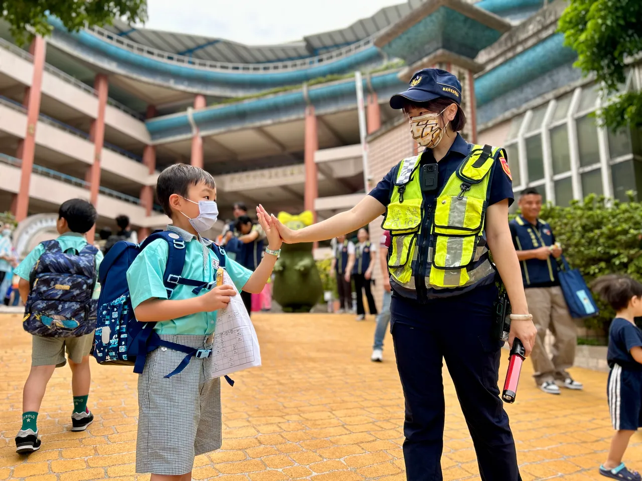 开学第一天见到妇幼队的女警姐姐站在学校门口指挥交通,小朋友格外的放心,还上前击掌表达感谢。警方提供