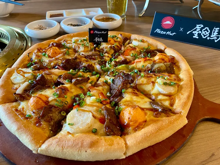 「月見七盎司厚燒牛比薩」選用厚切牛肉搭配屋馬獨門的日式果香燒肉醬，肉量更升級達40%。莊偉祺攝