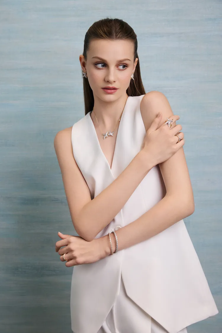 模特兒配戴Bird on a Rock by Tiffany石上鳥珠寶系列Lovebirds鏈墜耳環與Wings系列手環與戒指。品牌提供