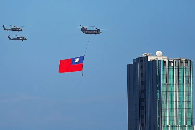 114年國旗大會今天隆重登場，陸軍一架CH-47SD契努克重型直升機吊掛巨幅國旗，伴隨2架UH-60M黑鷹直升機，飛越台北市上空。讀者提供